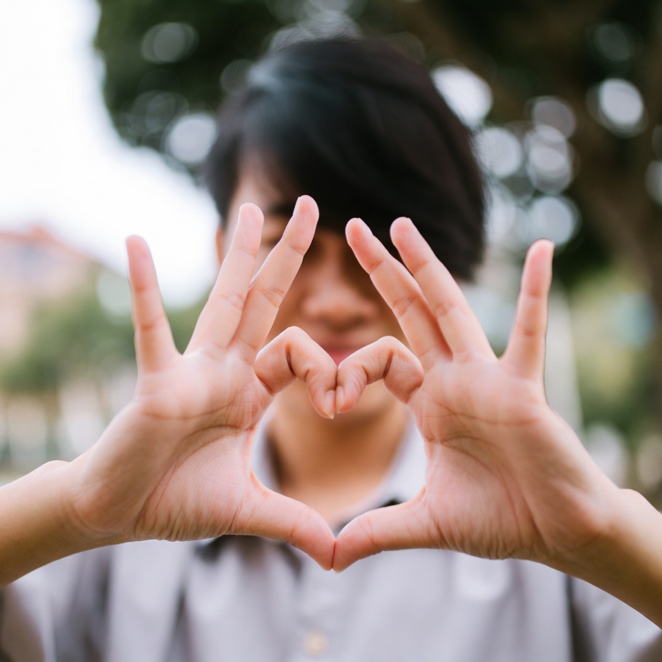 Hands forming a heart shape outdoors, symbolizing Christ-like, sacrificial love